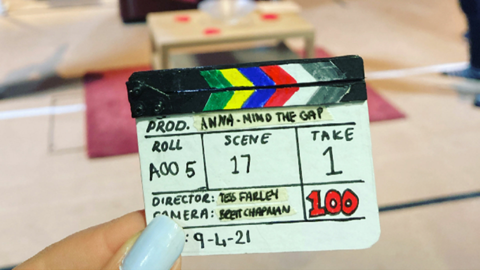 A tiny clapperboard with the text 'Prod. Anna - Mind the Gap; Roll A00 5; Scene 17; Take 1; Director: Tess Farley; Camera: Brett Chapman; 100; 9-4-21'