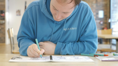 An artist draws in a notebook