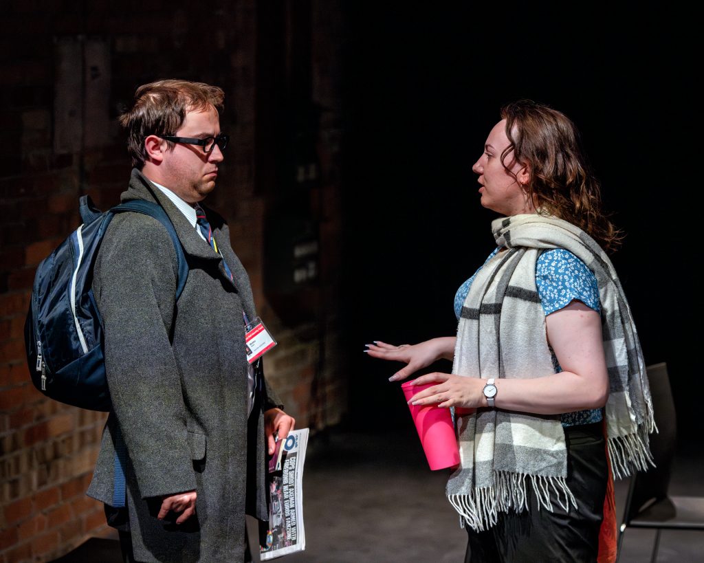 Photo of 7 CARRIAGES with two students on stage