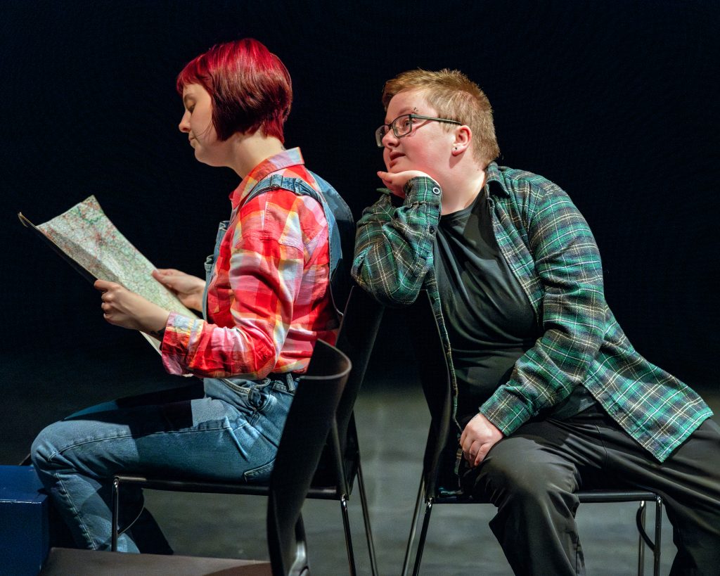 Photo of 7 CARRIAGES with two students on stage