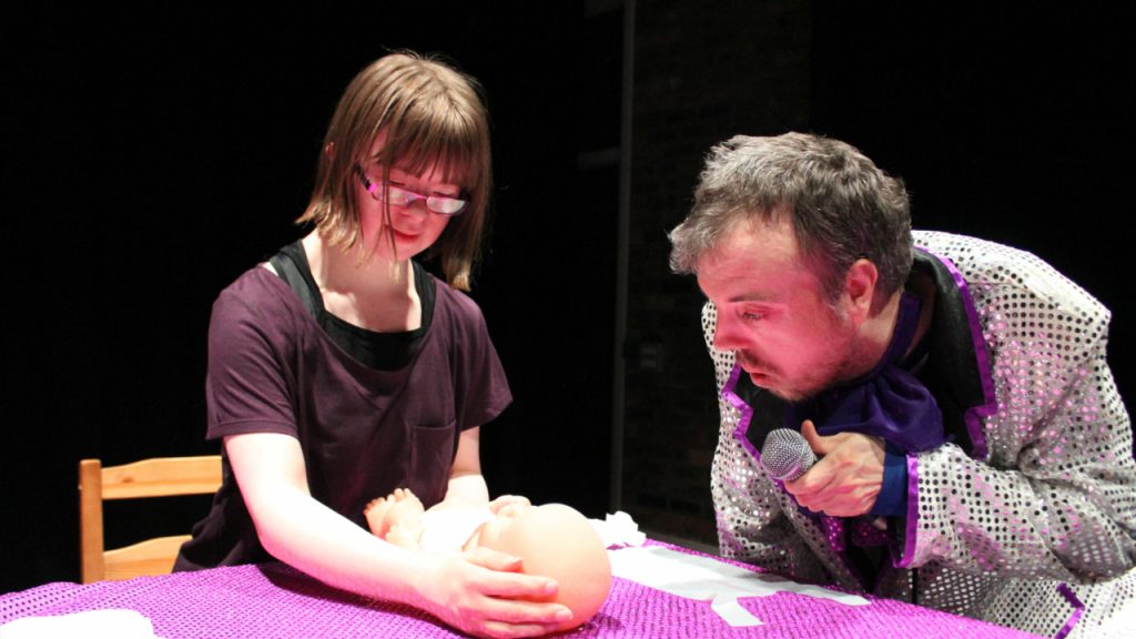 The cast of Mia on Stage hold a baby